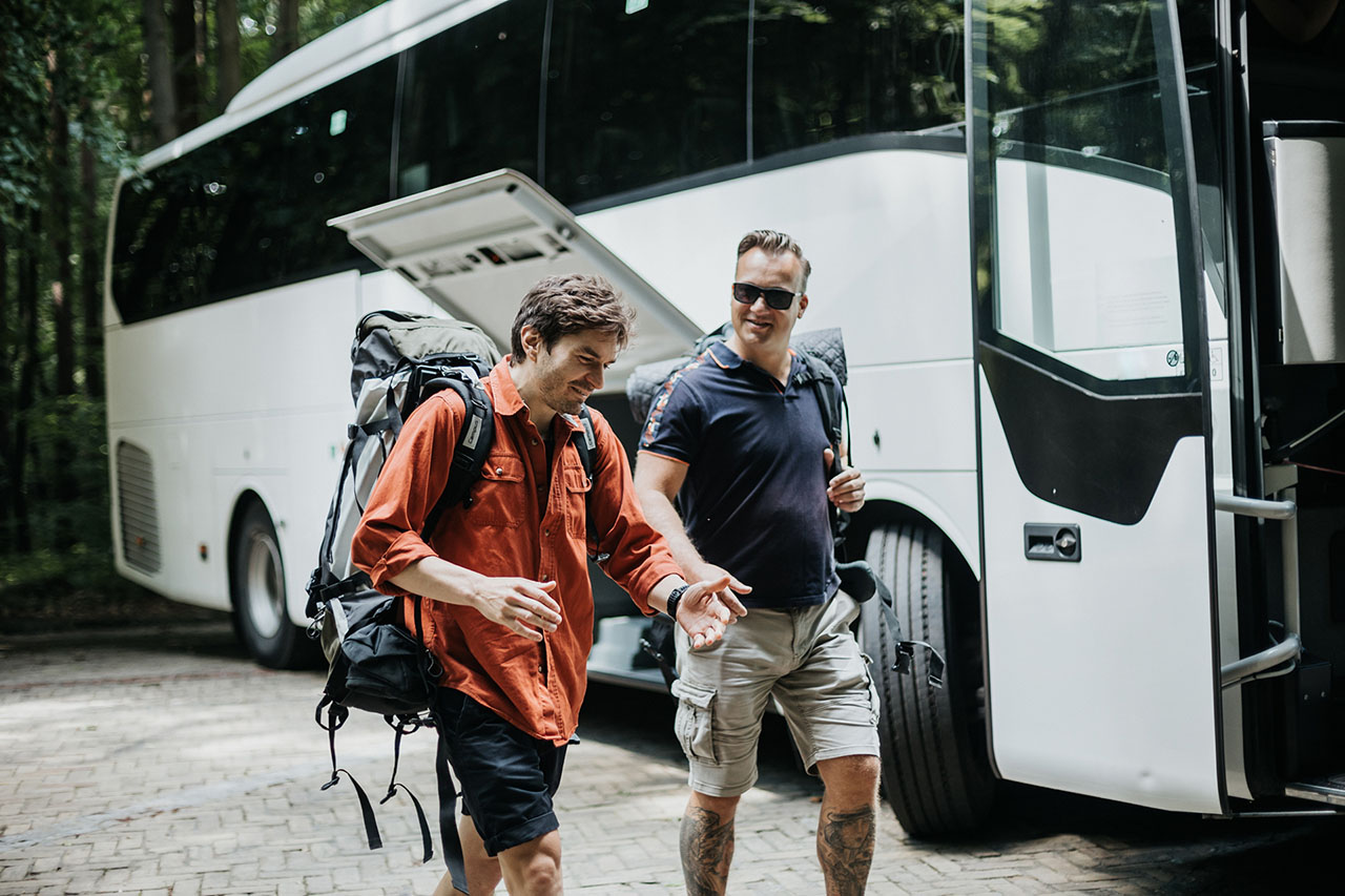 Two passengers outside the coach walk and talk